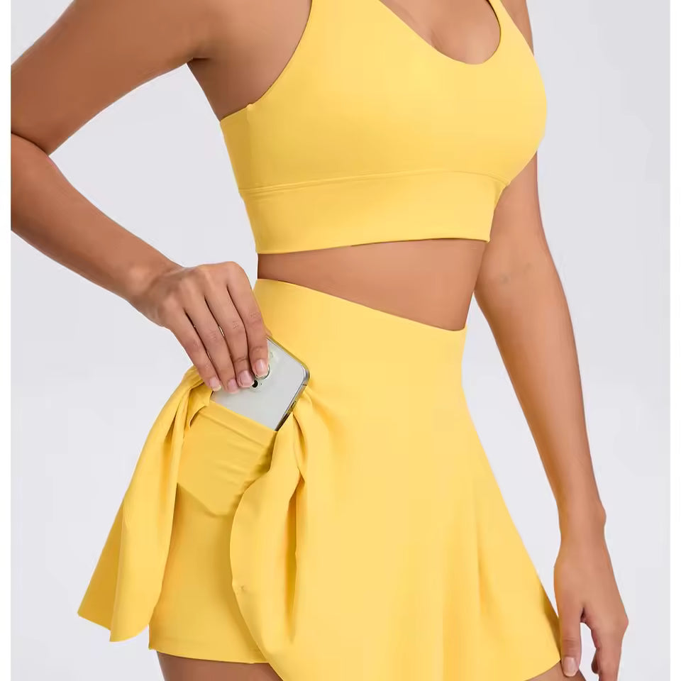 Conjunto feminino de yoga e desporto ao ar livre, de 2 peças, composto por sutiã desportivo e saia curta, ideal para treino, corrida e atividades casuais, com tecido respirável e confortável.